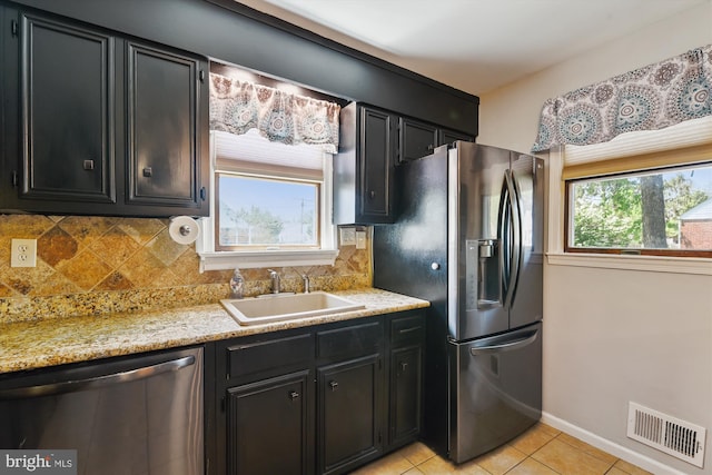 kitchen featuring a sink, dark cabinetry, stainless steel appliances, and visible vents