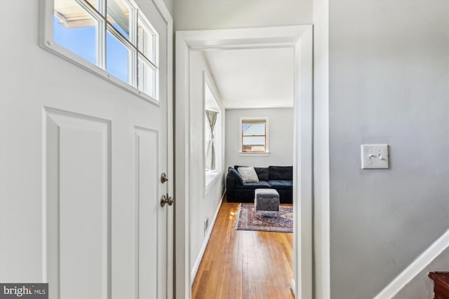 foyer entrance with baseboards and light wood-type flooring