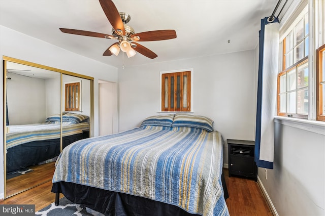 bedroom featuring baseboards, ceiling fan, a closet, and wood finished floors