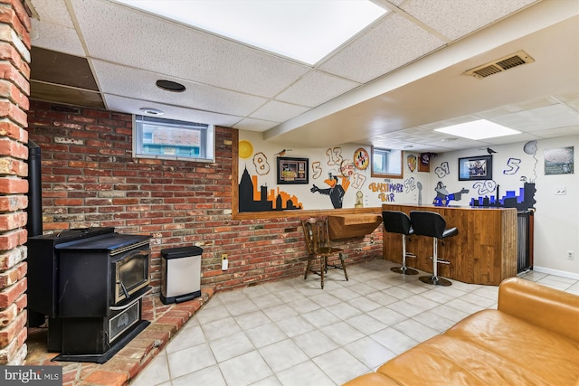 bar featuring visible vents, a wood stove, and a drop ceiling