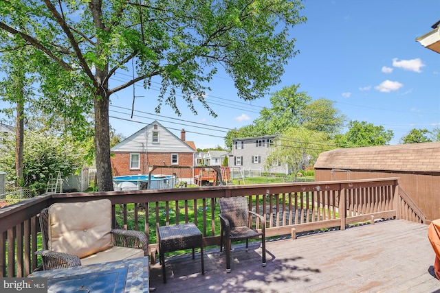 deck featuring fence, an outbuilding, a residential view, and an outdoor pool