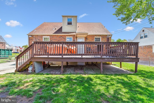 back of property featuring roof with shingles, brick siding, a wooden deck, stairway, and a yard