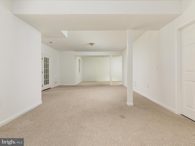 below grade area with baseboards and light colored carpet