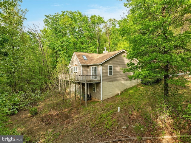 rear view of property with central air condition unit and a deck