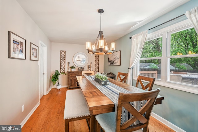 dining room with a chandelier, light wood-style floors, and baseboards