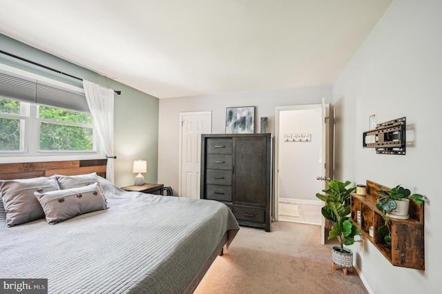 bedroom with light colored carpet and baseboards