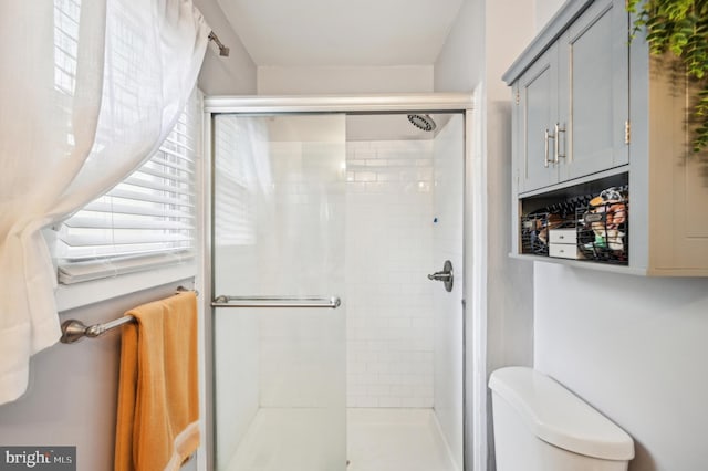 full bath featuring a shower stall and toilet