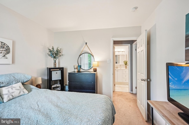 bedroom with light carpet and connected bathroom