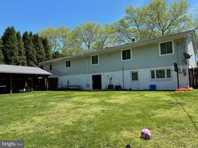 rear view of property with a yard and cooling unit