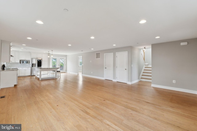 1600 Ballinger Ave, Landover, MD 20785 - unfurnished living room featuring recessed lighting, baseboards, stairs, light wood finished floors, and a sink