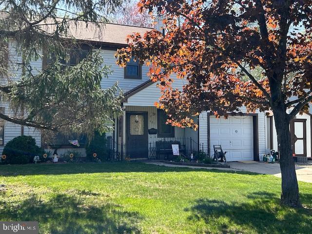 view of front of property featuring an attached garage, driveway, and a front yard