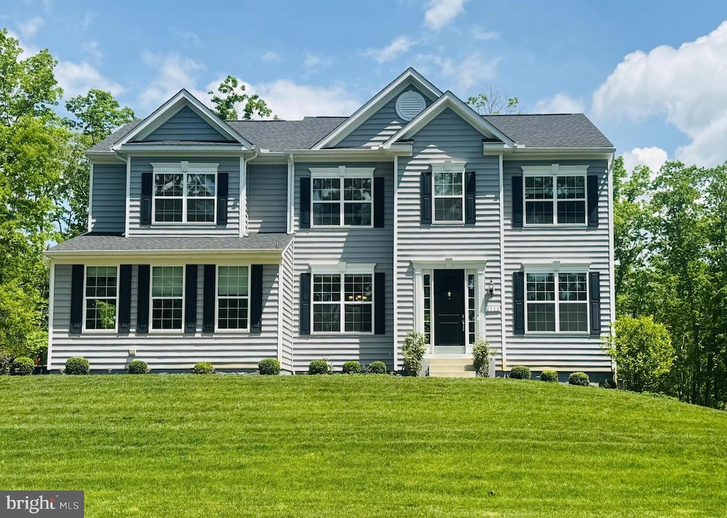 colonial-style house with a front lawn