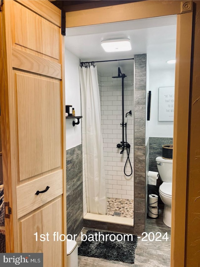 full bath with toilet and a stall shower