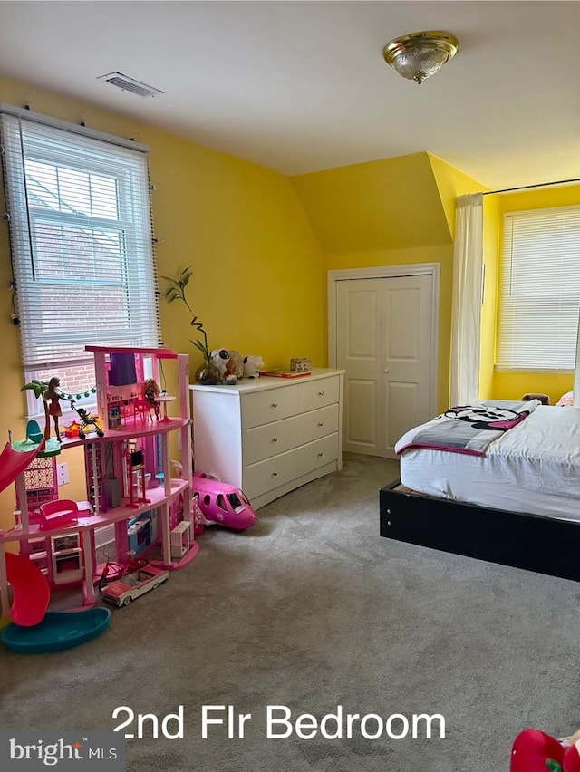 carpeted bedroom featuring visible vents