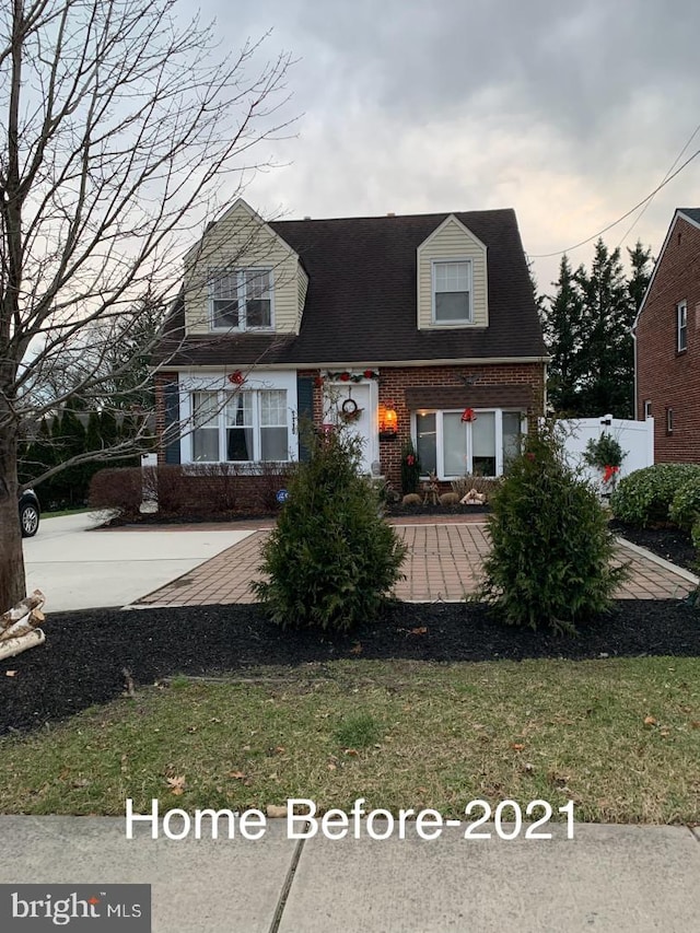 new england style home featuring brick siding