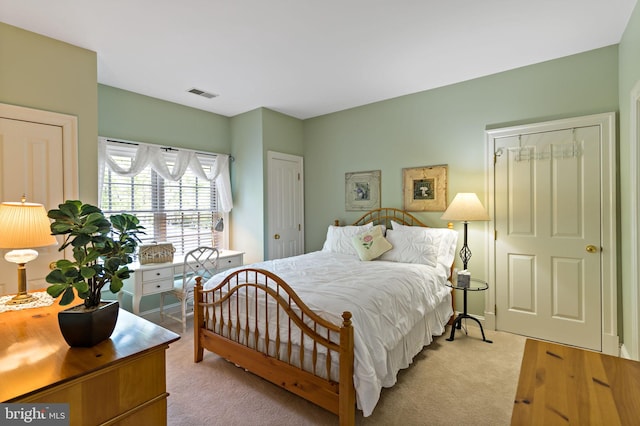 bedroom featuring visible vents and light carpet
