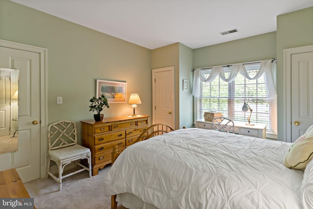 carpeted bedroom featuring visible vents