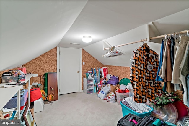interior space with carpet floors, lofted ceiling, and visible vents