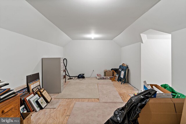 additional living space featuring vaulted ceiling and wood finished floors