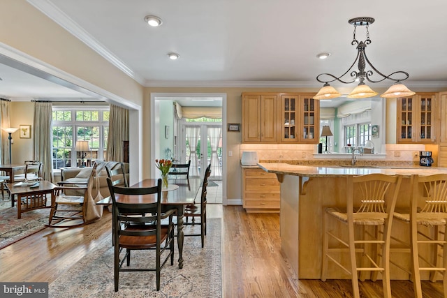 kitchen with glass insert cabinets, a healthy amount of sunlight, and a kitchen bar