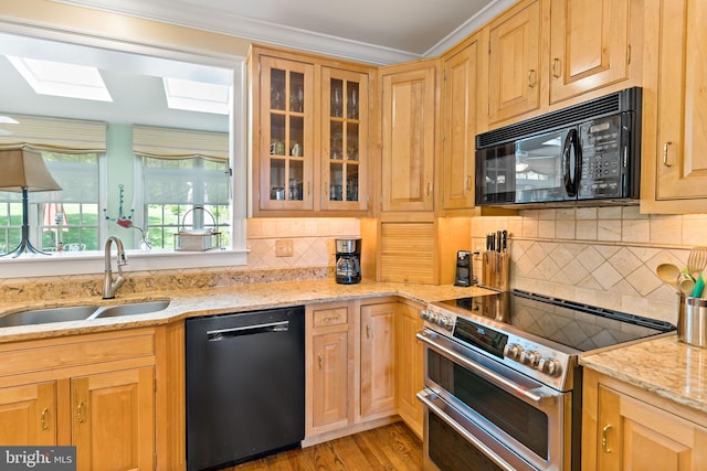 kitchen featuring a sink, decorative backsplash, light brown cabinetry, and black appliances