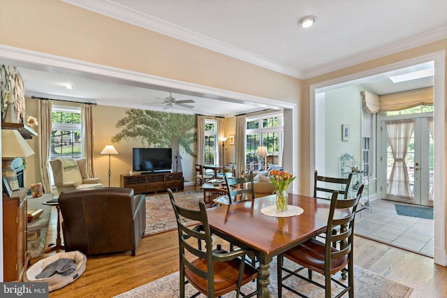 dining area with light wood-type flooring, ornamental molding, and ceiling fan
