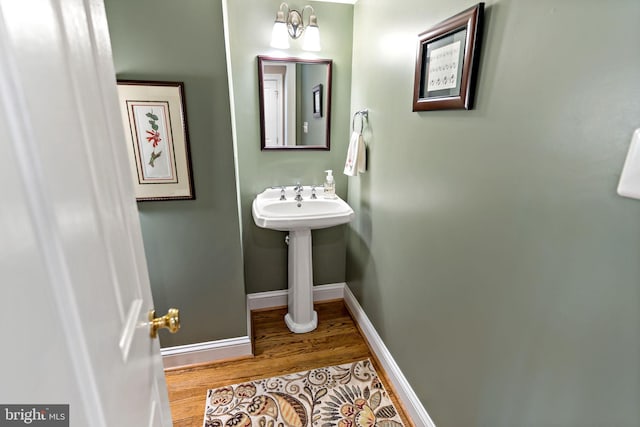 bathroom with baseboards and wood finished floors
