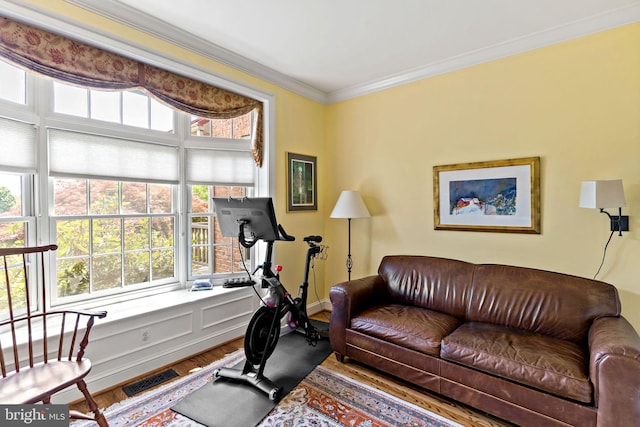 interior space featuring crown molding, visible vents, a healthy amount of sunlight, and wood finished floors