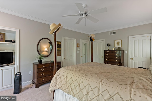 bedroom featuring visible vents, crown molding, multiple closets, light colored carpet, and a ceiling fan