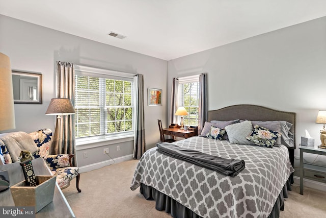 bedroom with baseboards, visible vents, and carpet