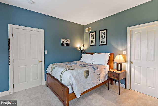 bedroom featuring light colored carpet and visible vents