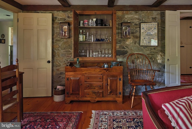 interior space with wood finished floors and beam ceiling
