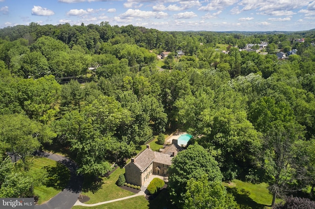 aerial view of property and surrounding area featuring a heavily wooded area