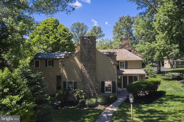view of front of home featuring a chimney and a front yard