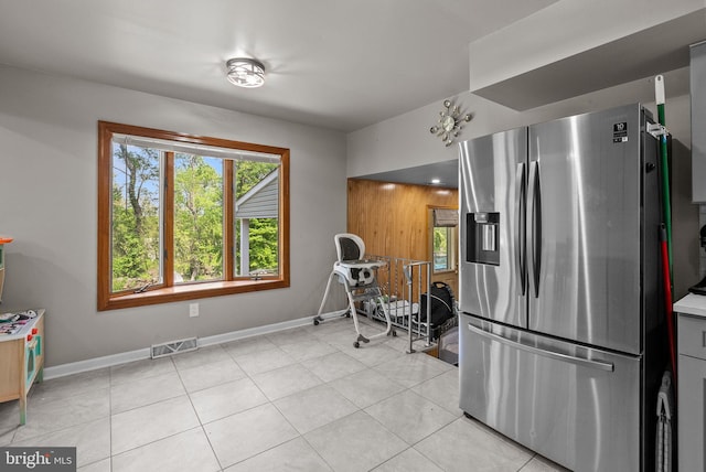 kitchen with visible vents, baseboards, stainless steel fridge, light countertops, and light tile patterned floors