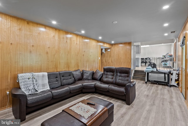 living room with visible vents, wood walls, wood finished floors, and recessed lighting