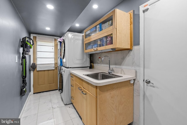 washroom with marble finish floor, recessed lighting, a sink, cabinet space, and stacked washer / drying machine