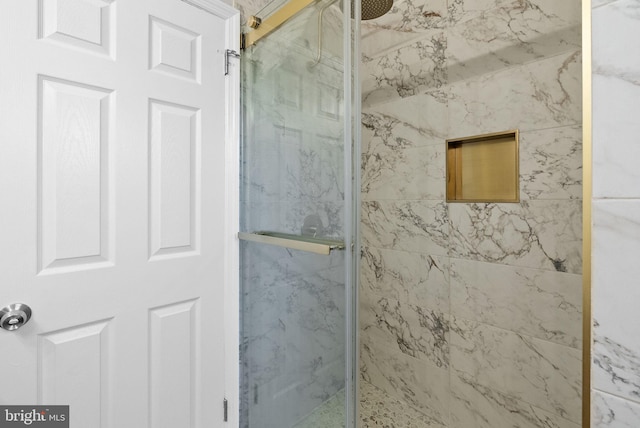 bathroom featuring a marble finish shower