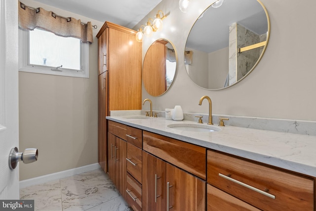 full bath with a sink, baseboards, double vanity, and marble finish floor