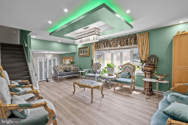 living area with recessed lighting, baseboards, stairs, and wood finished floors