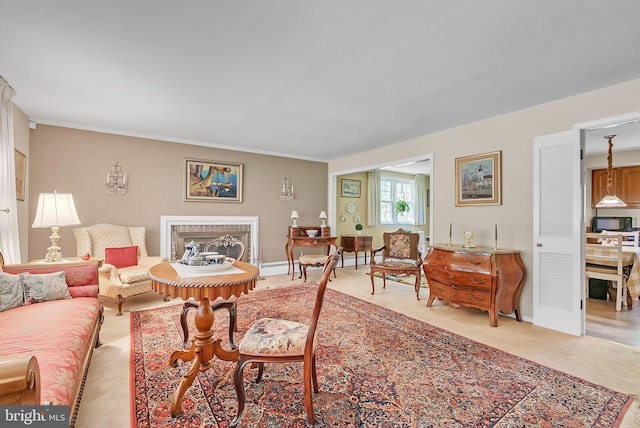 living area with crown molding, baseboards, and light carpet