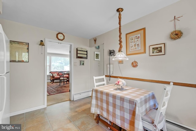dining area with light tile patterned floors, baseboards, and a baseboard radiator