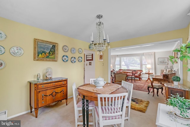 dining room with an inviting chandelier, baseboards, and light colored carpet