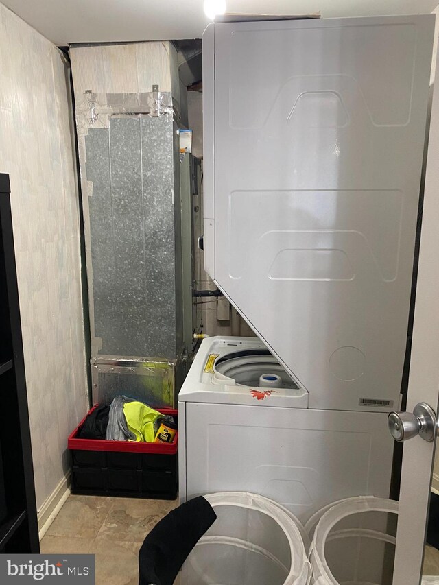 clothes washing area with laundry area and stacked washing maching and dryer