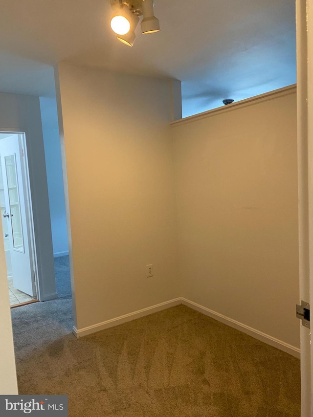 empty room featuring baseboards and carpet