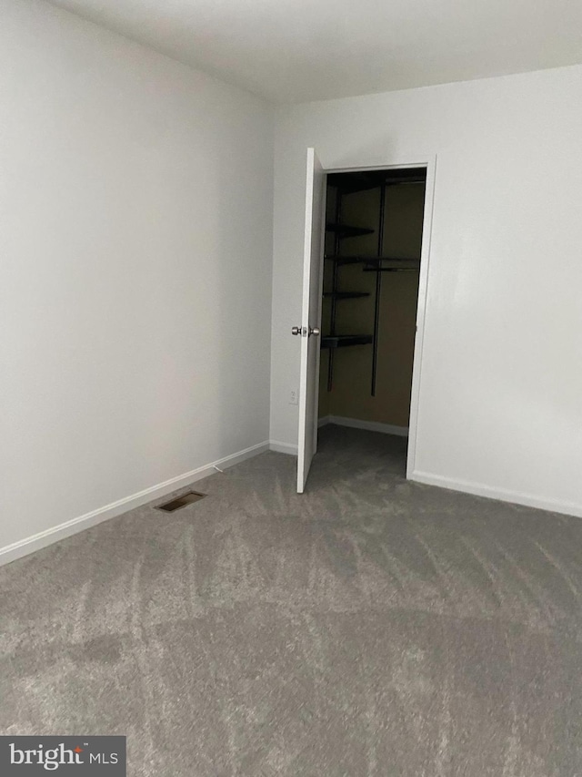 unfurnished bedroom featuring baseboards, visible vents, carpet, and a closet