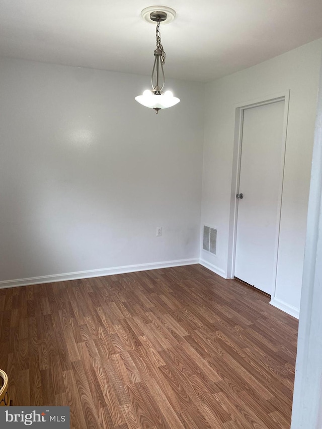 unfurnished dining area with visible vents, dark wood finished floors, and baseboards