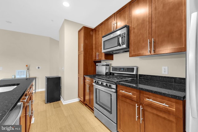 444 W Broad St Unit 407, Falls Church, VA 22046 - kitchen featuring appliances with stainless steel finishes, dark stone countertops, baseboards, brown cabinetry, and recessed lighting