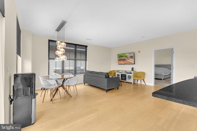 444 W Broad St Unit 407, Falls Church, VA 22046 - dining space featuring light wood-style floors, a chandelier, and baseboards