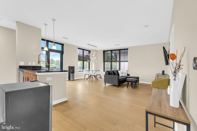 444 W Broad St Unit 407, Falls Church, VA 22046 - living area with light wood finished floors, plenty of natural light, a chandelier, and baseboards